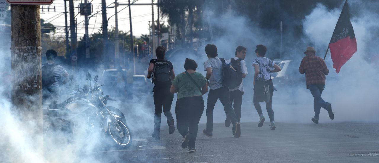 Flucht vor Tränengas. Kurz vor Anpfiff der Partie Brasilien : Kroatien lösten Polizisten gewaltsam eine Demonstration auf. Foto: Philippe Desmantez / AFP