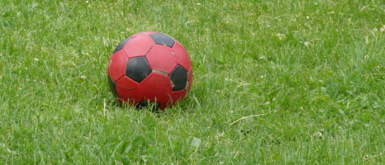 Foto: Roter Fußball auf grünem Rasen | CC BY 2.0 | stachelbeer / flickr.com