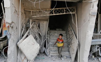 Zwischen Rebellen, IS und Assad: Ein Kind vor einem zerstörten Gebäude in der syrischen Stadt Arbin. Foto: Abdulmonam Eassa | AFP