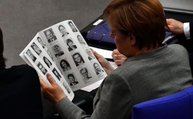Angela Merkel beim Blick in das Abgeordneten-Verzeichnis des neuen Bundestags. Foto: John MacDougall |AFP