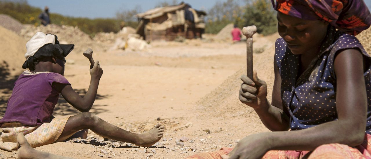 Eine Frau und ein Kind zerkleinern Gestein, welches aus einer Kobaltmine bei Lubumbashi extrahiert wurde. Foto: Junior Kannah | AFP