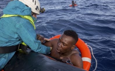 Ein Mitglied der NGO Sea-Watch hilft einem Flüchtenden an Bord zu kommen. Foto: Alessio Paduano / AFP