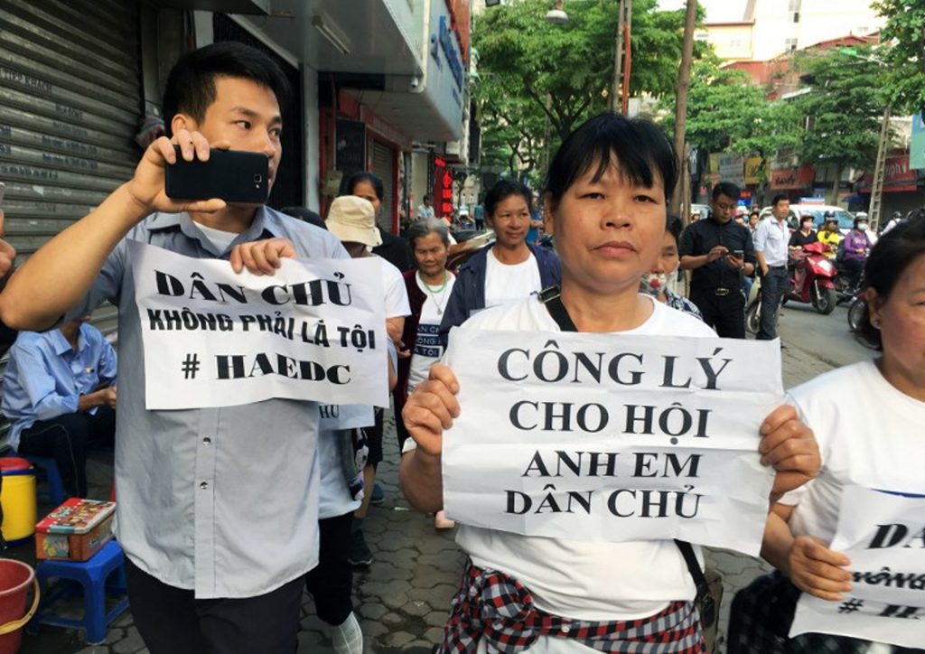 Ein Demonstrant hält die Losung „Demokratie ist kein Verbrechen“ vor dem Gericht in Hanoi hoch. Foto: Jenny Vaughan / AFP