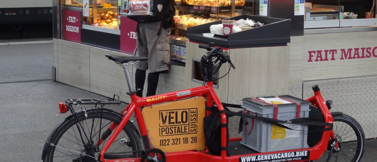 Bild:  Messager à vélo, cyclomessagerie « La Vélopostale », sur un quai de la gare Cornavin à Genève. Vélo cargo « Bullitt » (Larry vs Harry). | MHM55 / wikimedia | CC BY-SA 4.0