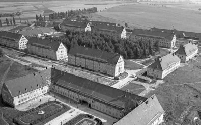 Altes Schwarz-Weiß-Foto der Zittwerke von oben. Zu sehen sind mehrere längliche Gebäude um ein kleines Waldstück herum, dahinter eine Grünfläche. (Foto: ZDF / Privatfoto)