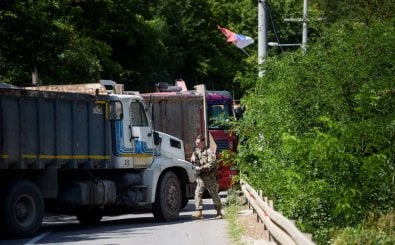 A US NATO soldier serving in Kosovo patrols next to a road barricade set up by ethnic Serbs near the town of Zubin Potok on August 1, 2022. – Kosovo’s government late on July 31, 2022, postponed for a month the implementation of new border rules that sparked tensions in the north of the country where ethnic Serbs blocked roads and unknown gunmen fired on police. (Photo by Armend NIMANI / AFP)