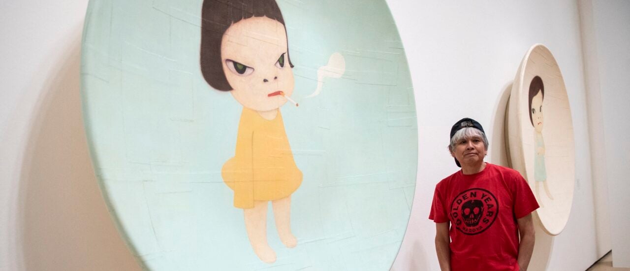 Japanese artist Yoshitomo Nara poses for photographers next to artwork „Slight Fever, 2001“ during the presentation of the retrospective art exhibition „Yoshitomo Nara“ at the Guggenheim Bilbao Museum in the Spanish Basque city of Bilbao on June 27, 2024. (Photo by ANDER GILLENEA / AFP) / RESTRICTED TO EDITORIAL USE – MANDATORY MENTION OF THE ARTIST UPON PUBLICATION – TO ILLUSTRATE THE EVENT AS SPECIFIED IN THE CAPTION