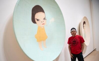 Japanese artist Yoshitomo Nara poses for photographers next to artwork „Slight Fever, 2001“ during the presentation of the retrospective art exhibition „Yoshitomo Nara“ at the Guggenheim Bilbao Museum in the Spanish Basque city of Bilbao on June 27, 2024. (Photo by ANDER GILLENEA / AFP) / RESTRICTED TO EDITORIAL USE – MANDATORY MENTION OF THE ARTIST UPON PUBLICATION – TO ILLUSTRATE THE EVENT AS SPECIFIED IN THE CAPTION