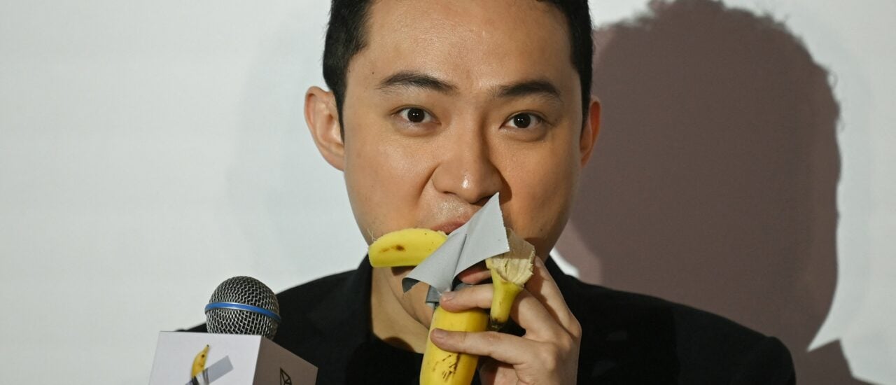 Chinese-born crypto founder Justin Sun eats a banana artwork composed of a fresh banana stuck to a wall with duct tape, in Hong Kong on November 29, 2024, after buying the provocative work of conceptual art by Italian artist Maurizio Cattelan at a New York auction for $6.2 million. – The debut of the edible creation entitled „Comedian“ at the Art Basel show in Miami Beach in 2019 sparked controversy and raised questions about whether it should be considered art — Cattelan’s stated aim. (Photo by Peter PARKS / AFP)