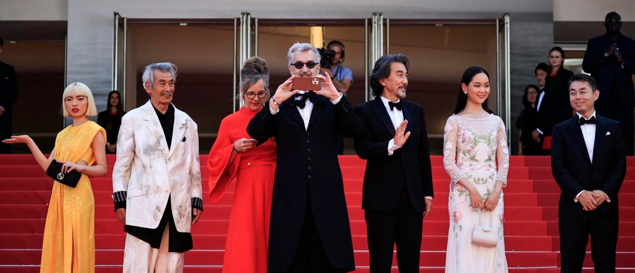 German director Wim Wenders (C) takes photos as he arrives with (from L) Japanese actress Aoi Yamada, Japanese actor Min Tanaka, German photographer Donata Wenders, Japanese actor Koji Yakusho, Japanese actress Arisa Nakano and Japanese actor Tokio Emoto for the screening of the film „Perfect Days“ during the 76th edition of the Cannes Film Festival in Cannes, southern France, on May 25, 2023. (Photo by Valery HACHE / AFP)