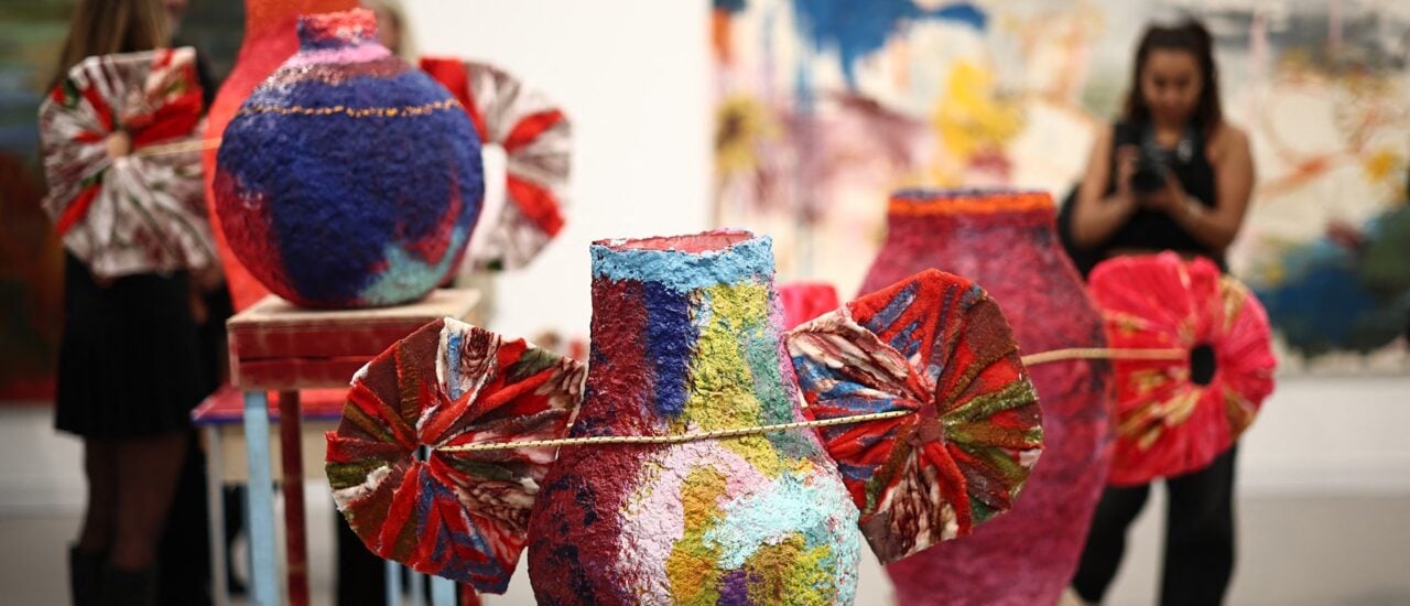 Guests look at works from the series ‚Monuments‘ by Studio Lenca at the Carl Freedman Gallery at the Frieze London 2025 exhibition in London on October 15, 2025. (Photo by HENRY NICHOLLS / AFP) / RESTRICTED TO EDITORIAL USE – MANDATORY MENTION OF THE ARTIST UPON PUBLICATION – TO ILLUSTRATE THE EVENT AS SPECIFIED IN THE CAPTION