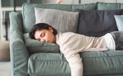 Eine Frau entspannt sich mit geschlossenen Augen auf einer Couch. Foto: Seba/Shutterstock