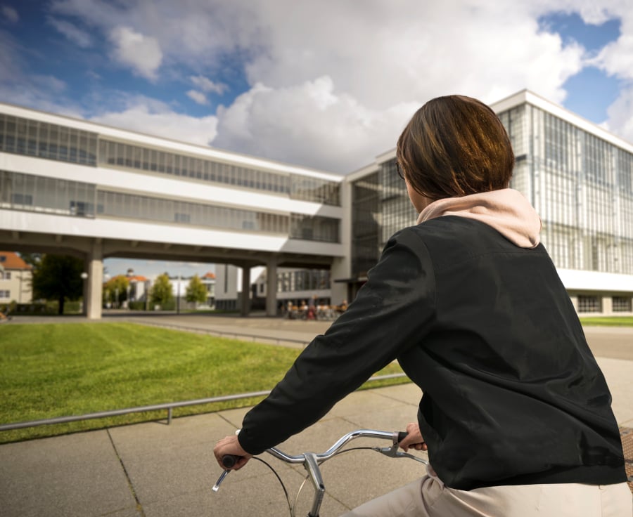 Frau auf Fahrrad vorm Bauhaus. Bild: SMG Dessau-Roßlau, Meike Kenn