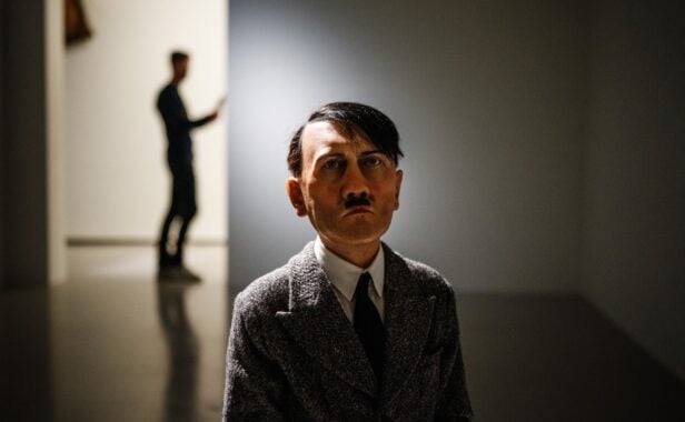 This photograph taken at the Bourse de Commerce – Pinault Collection in Paris on March 13, 2024, shows the work of Italian visual artist Maurizio Cattelan – with a sculpture of Hitler kneeling with his back to the ground, looking like a child, on display during a press preview ahead of its new exhibition of works. Entitled „Le monde comme il va“ („The world as it is“), the exhibition runs until September 2024, and features „around sixty works from this private collection, which comprises more than 10,000 works, brought together in their relationship to the present and current events, with artists who react and whose works provoke reactions“, curator Jean-Marie Gallais told AFP. (Photo by Dimitar DILKOFF / AFP) / RESTRICTED TO EDITORIAL USE – MANDATORY MENTION OF THE ARTIST UPON PUBLICATION – TO ILLUSTRATE THE EVENT AS SPECIFIED IN THE CAPTION