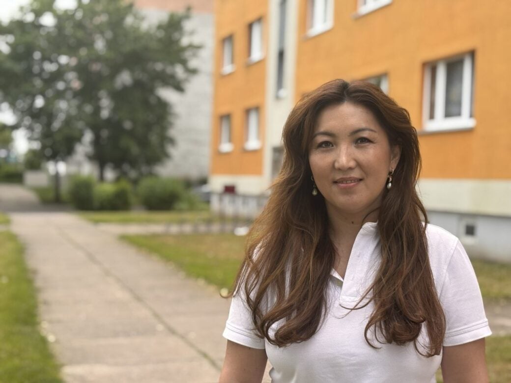 Die Geschäftsführerin des Dachverbandes der Migrantenorganisationen LAMSA, Undra Dreßler, steht in Stendal vor einem Wohnhaus. Foto: Marie Landes