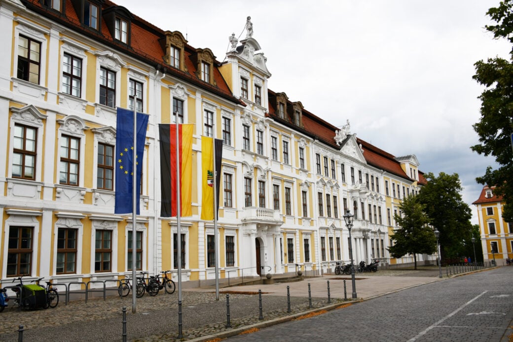 Landtagswahl Sachsen-Anhalt: Der Landtag von Magdeburg in der Außenansicht. Davor wehen die Fahnen der EU, von Deutschland und von Sachsen-Anhalt. Foto: Nitpicker | Shutterstock.com